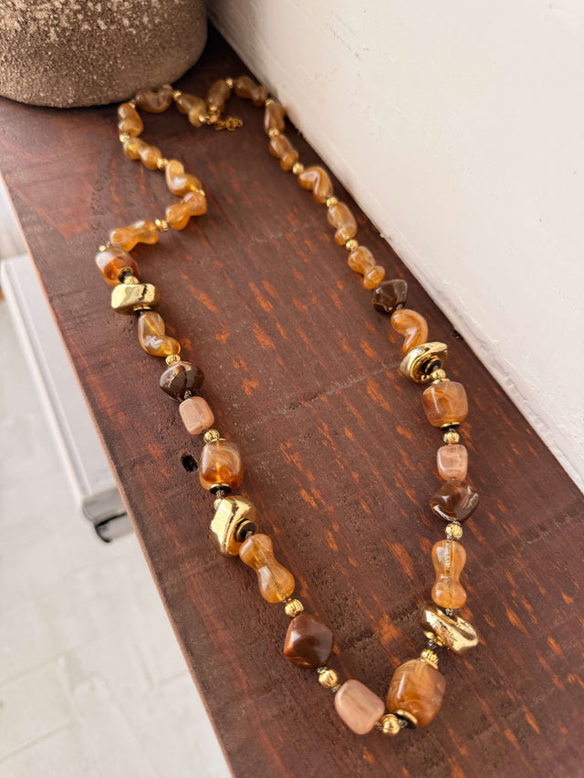 Colar Comprido Pedras Em Resina em tons quentes com detalhes em dourado.