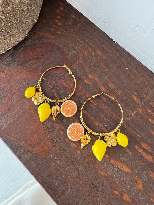 Brincos argolas coloridas com pendentes de limão e laranja, perfeitos para um look vibrante e alegre.