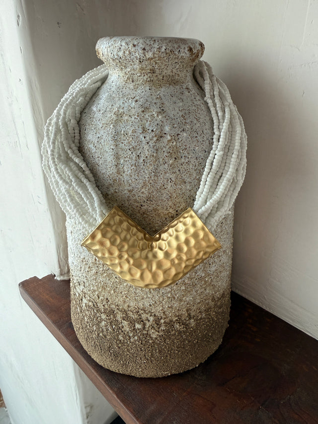Colar com missangas brancas e detalhe em metal dourado, ideal para looks casuais e elegantes.