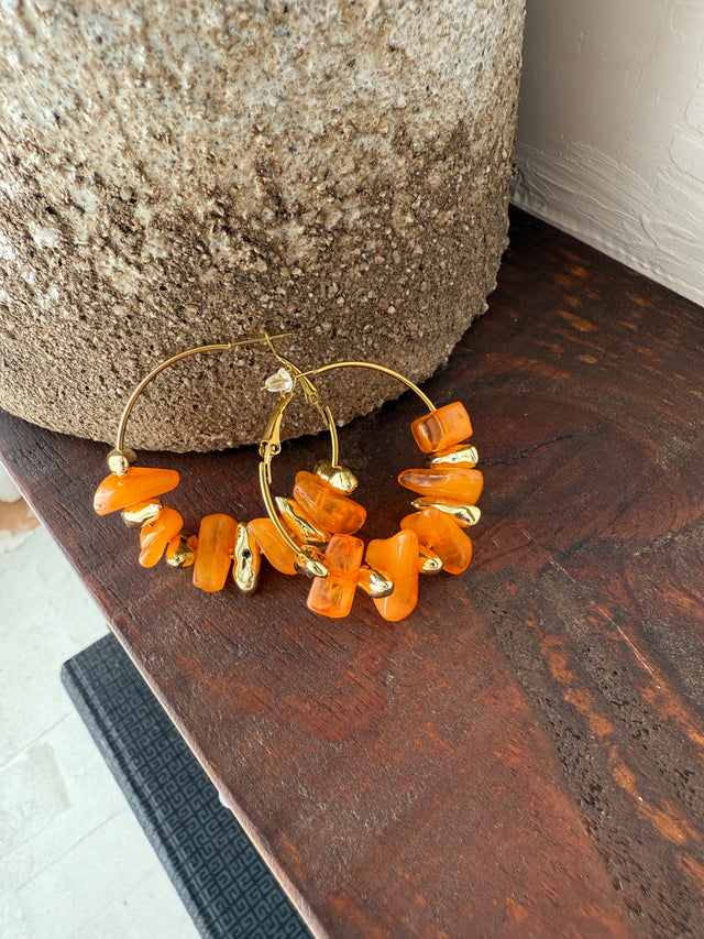 Argolas com pedras laranja vibrantes, perfeitas para um look alegre e moderno.