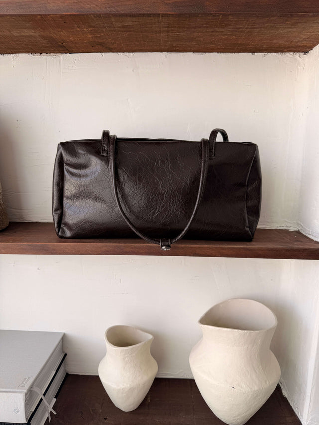 Tote Bag Ecopele castanho em cima de prateleira de madeira