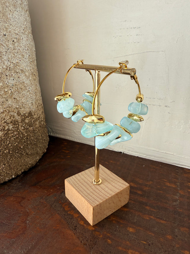 Brincos argolas com pedras coloridas em azul, design moderno e elegante, perfeito para acessórios vibrantes.