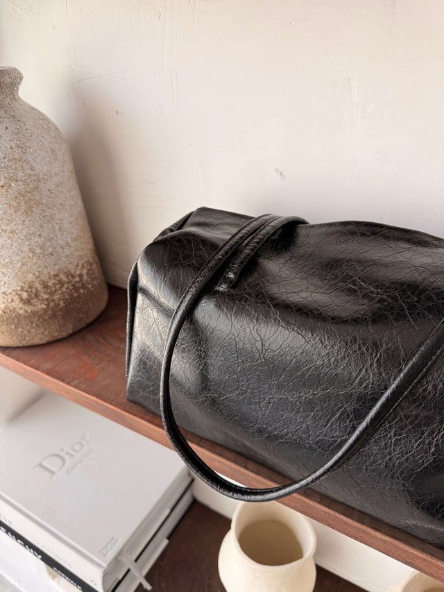 Tote Bag Ecopele em preto, com alça e textura elegante.