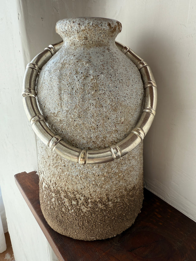 Vaso de cerâmica com colar metálico sofisticado, ideal para decoração contemporânea e elegante.