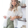Blusa bordada branca com decote em bico e mangas longas, ideal para looks delicados e modernos.