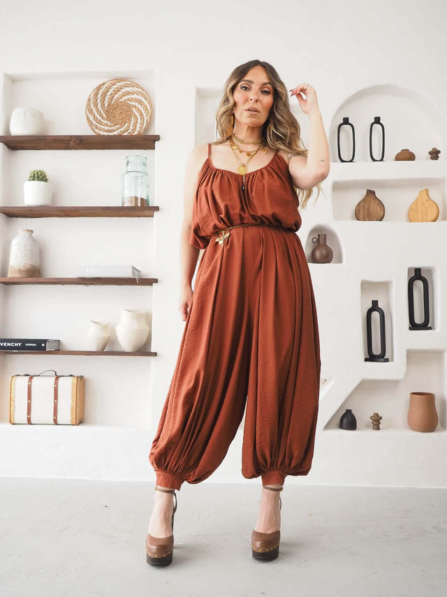 Mulher a usar um Macacão Largo de Alças em tom terracota, com design fluido e elegante, ideal para dias quentes.