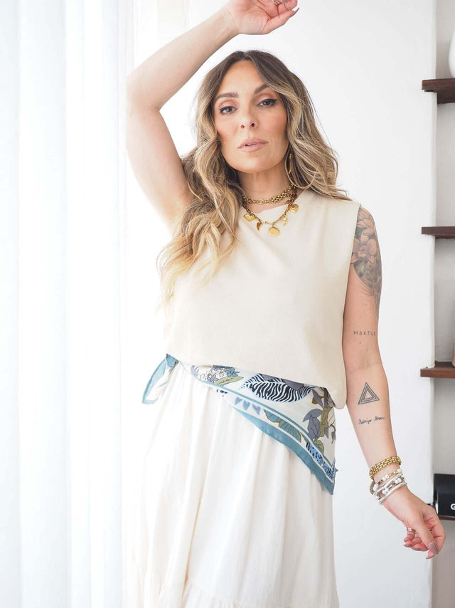 Modelo usando uma camisola malha manga cava com um lenço, destacando conforto e estilo minimalista.