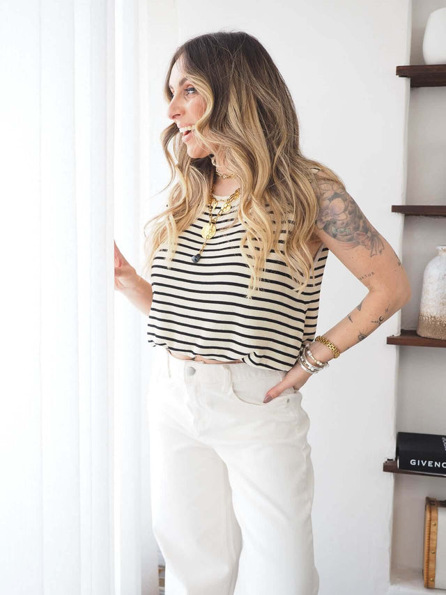 Modelo usando uma camisola malha manga cava às riscas, destacando conforto e elegância para o verão.