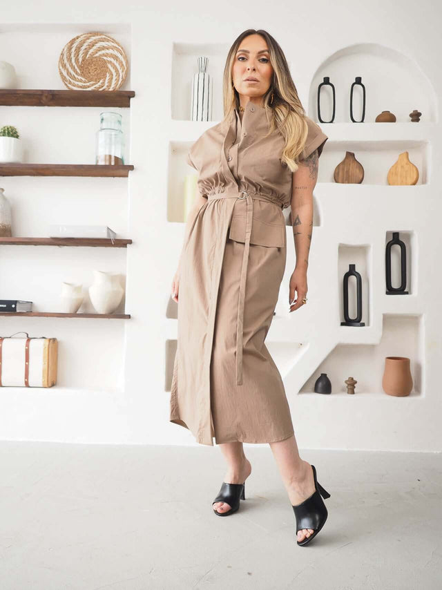 Modelo usando um Vestido Midi Safari Ajustável, elegante e com cintura ajustável, em ambiente moderno.