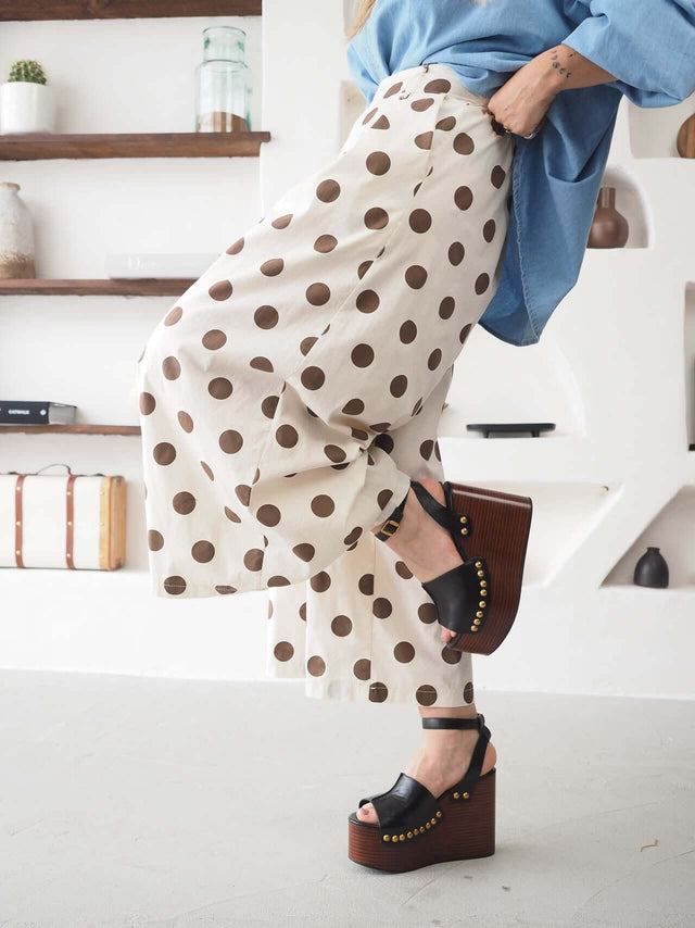 Calças Culote às Bolas femininas com padrão polka dots e corte fluido, perfeitas para um look casual chic.