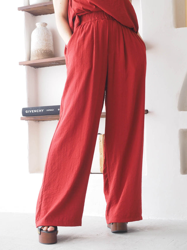 Calças pantalona fluídas de mulher em tecido leve com cintura elástica, ideal para um look moderno e confortável.
