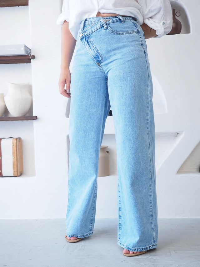 Calças de ganga wide leg com cintura cruzada, proporcionando conforto e estilo moderno.