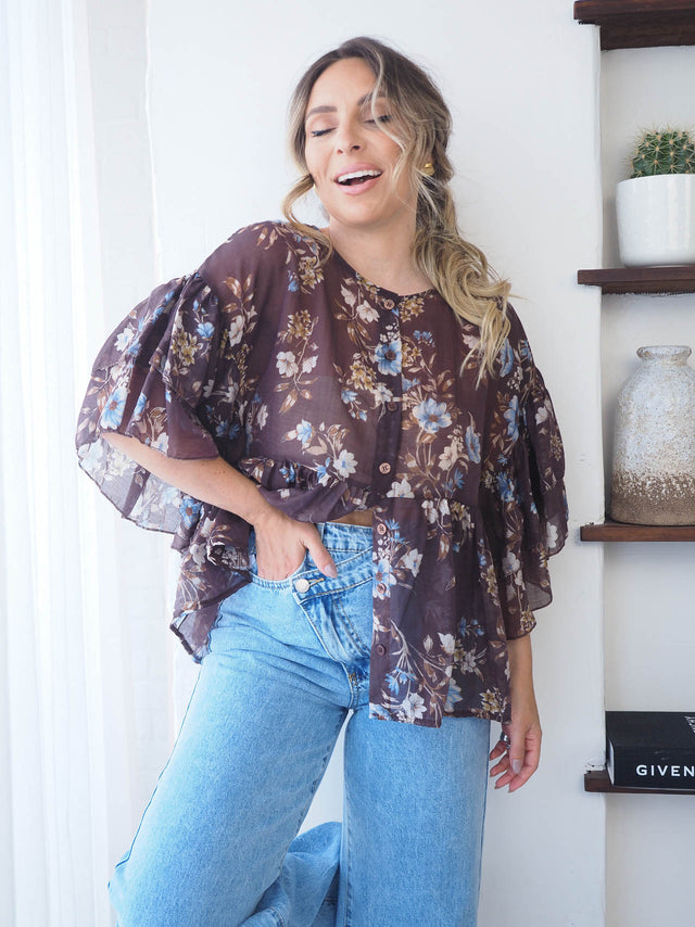 Blusa Florida semi-transparente com padrão floral, perfeita para um look romântico e elegante.