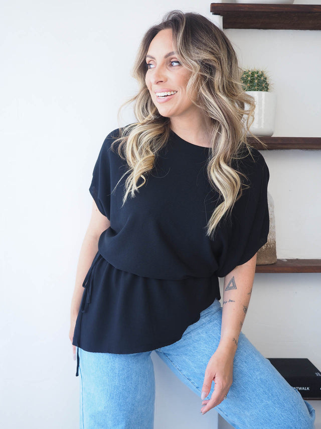 Camisola malha ajustável em preto, confortável e moderna, ideal para dias quentes e looks descontraídos.