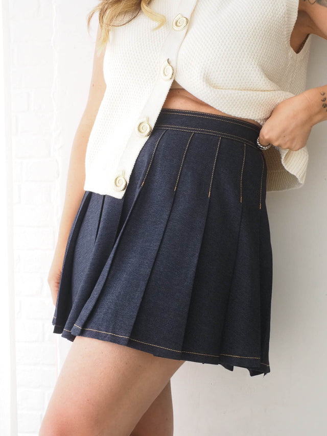 Saia de ganga curta plissada, combina estilo e feminilidade, ideal para looks casuais ou compostos.