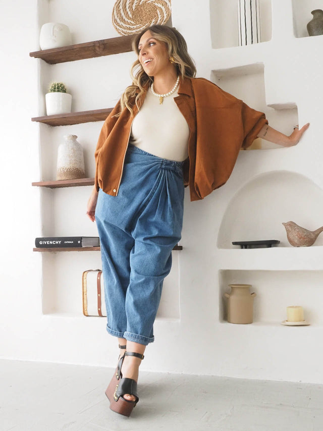 Calças baggy balloon cintura alta em denim, combinadas com blusão oversized, criando um look moderno e elegante.