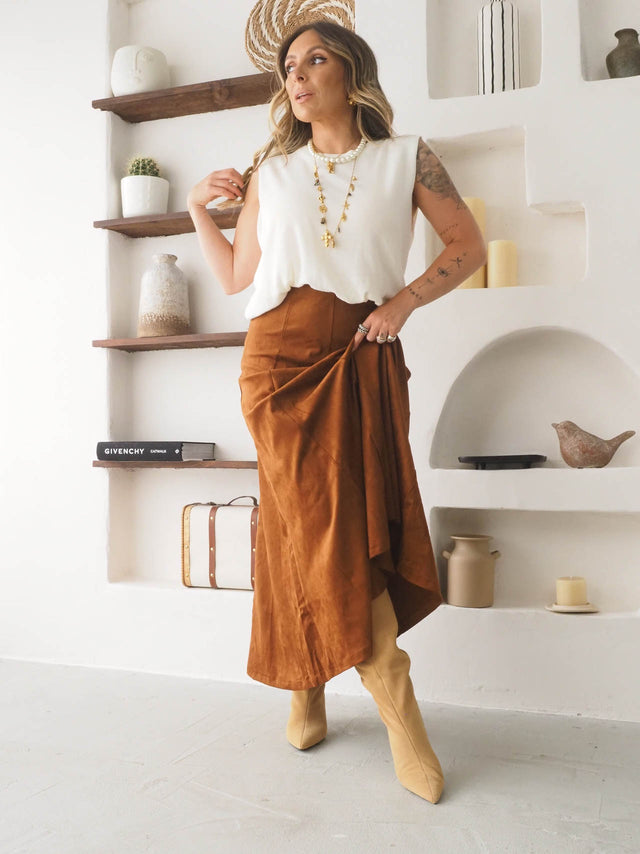 Saia midi com efeito camurça, blusa branca e botas, look elegante e versátil para primavera/verão.