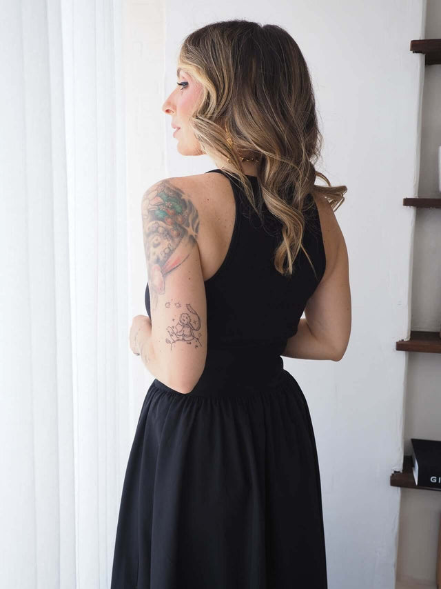 Top Canelado feminino em malha canelada, ajuste justo, cor preta, combinado com saia larga.