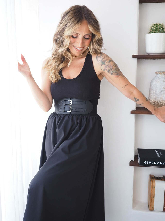 Top Canelado preto em malha com riscas, ajustado ao corpo, estilo oversized, combinado com saia elegante.