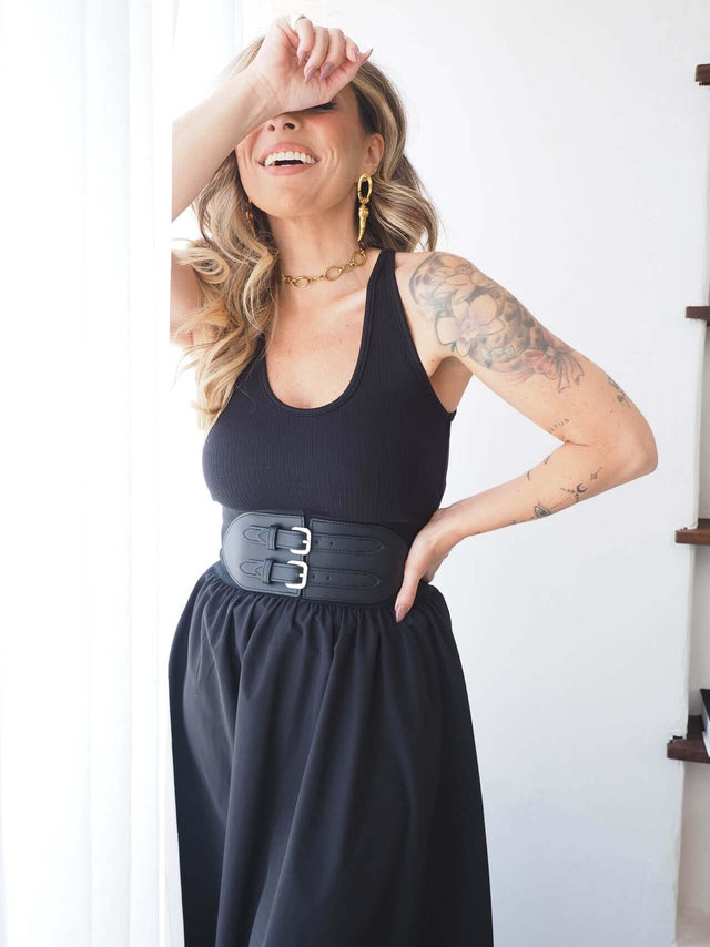 Top Canelado justo em malha riscas com saia larga e cinto preto, ideal para um look moderno e versátil.