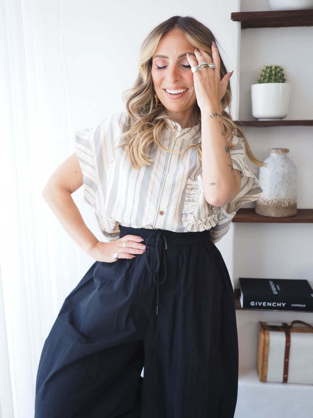Camisa Riscas feminina oversized em linho, padrão de riscas, combinada com calças largas de ganga, estilo descontraído e elegante.