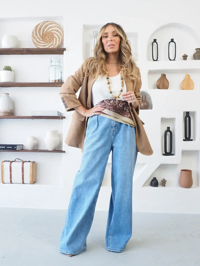 Mulher a usar calças de ganga pantalona de corte amplo e estilo casual.