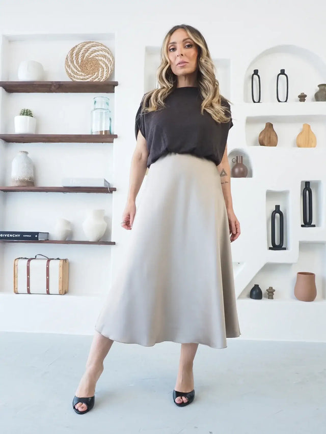 Saia Midi em Cetim taupe com movimento fluido, modelo evasé.