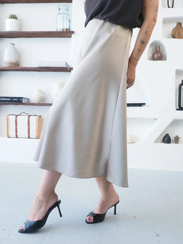 Saia Midi em Cetim em tom bege com caimento fluido e elegante.