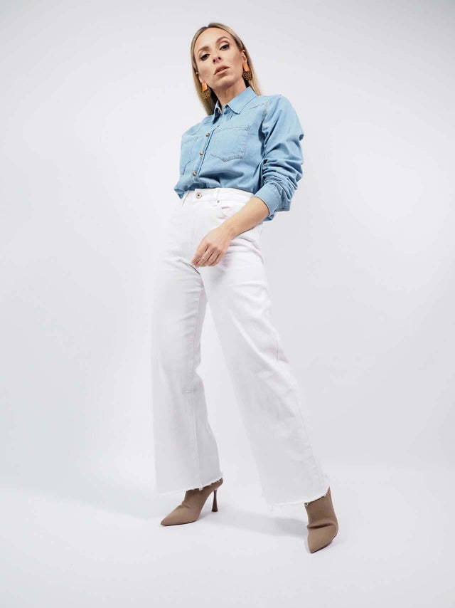 Camisa de ganga, combinada com umas calças brancas.