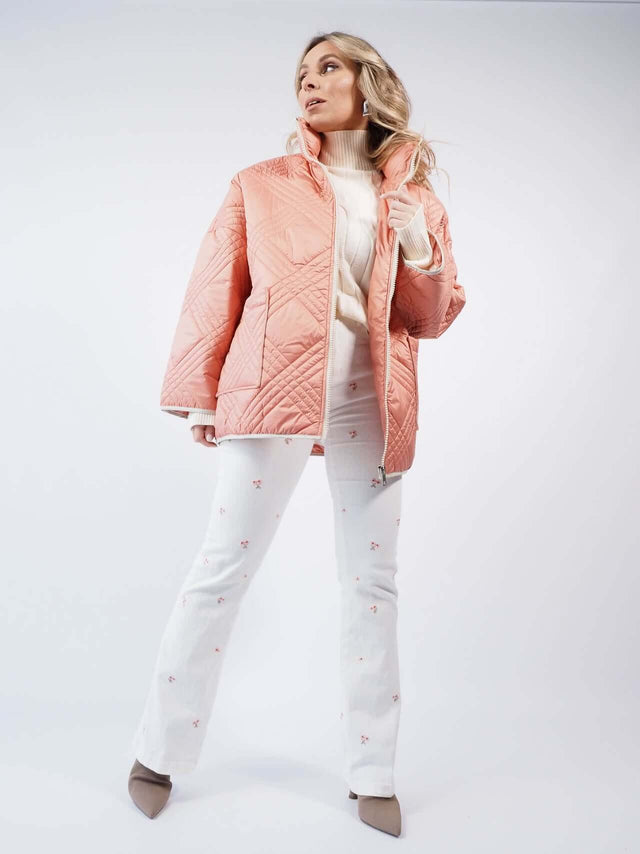 Calças de ganga brancas, com flores bordadas em tons de rosa.