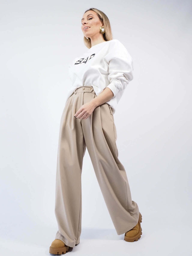 Calças em tecido fluído com fecho de correr metálico e botões.