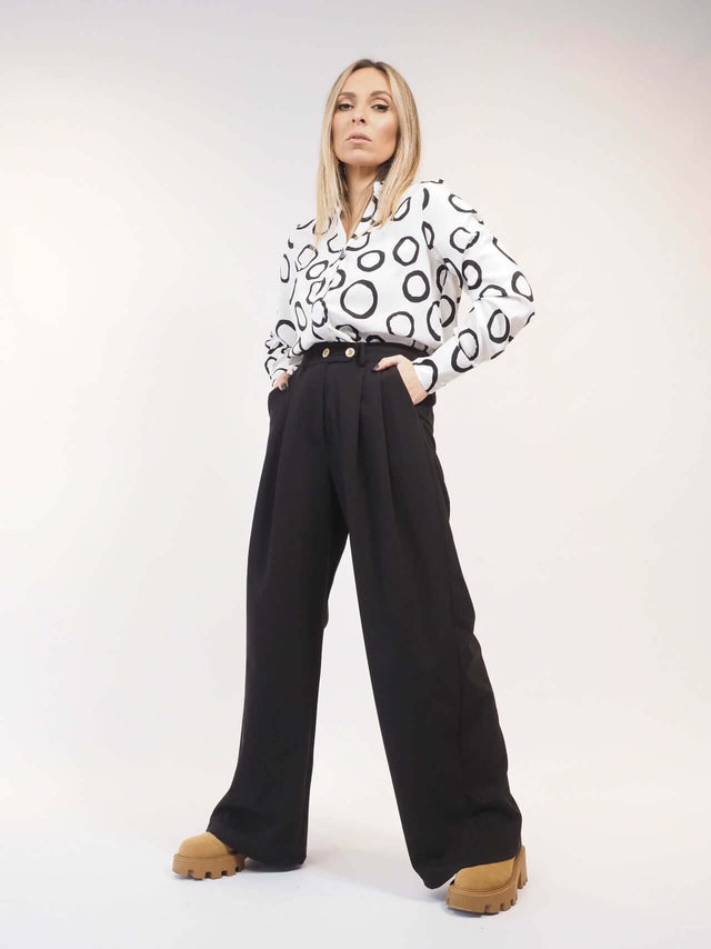 Calças pantalonas com bolsos laterais, acrescentam uma utilidade extra à silhueta relaxada.