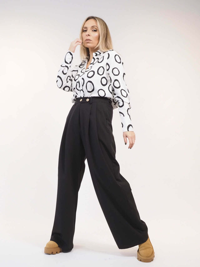 Calças em tecido largas com pregas à frente.