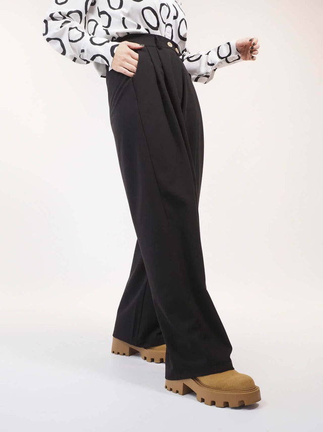 Calças pantalona, de tecido macio e fluído.