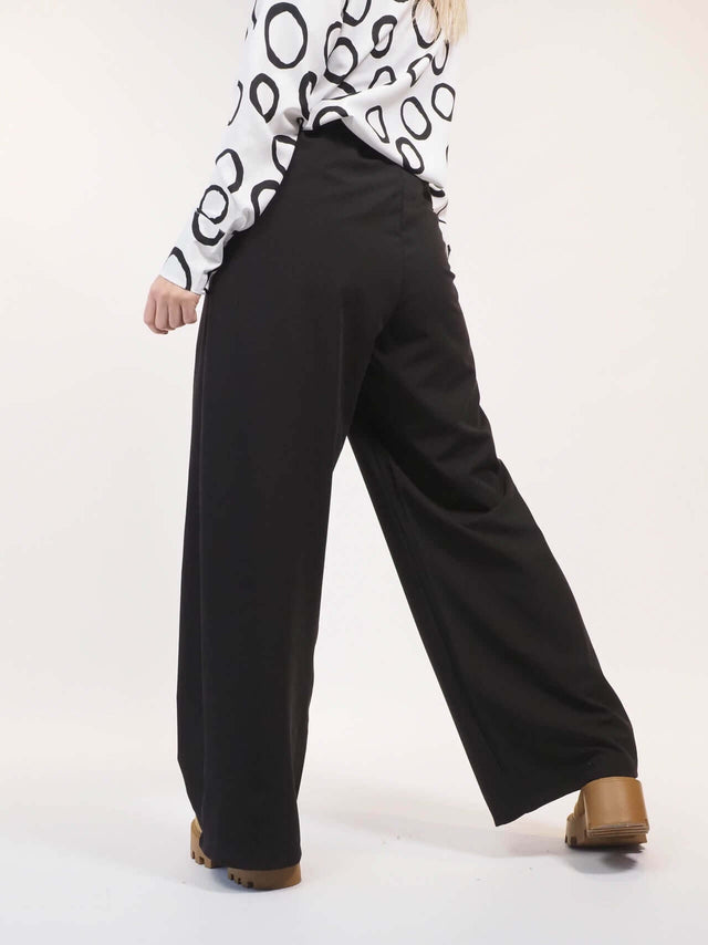 Calças pantalonas com vista de pormenor atrás.