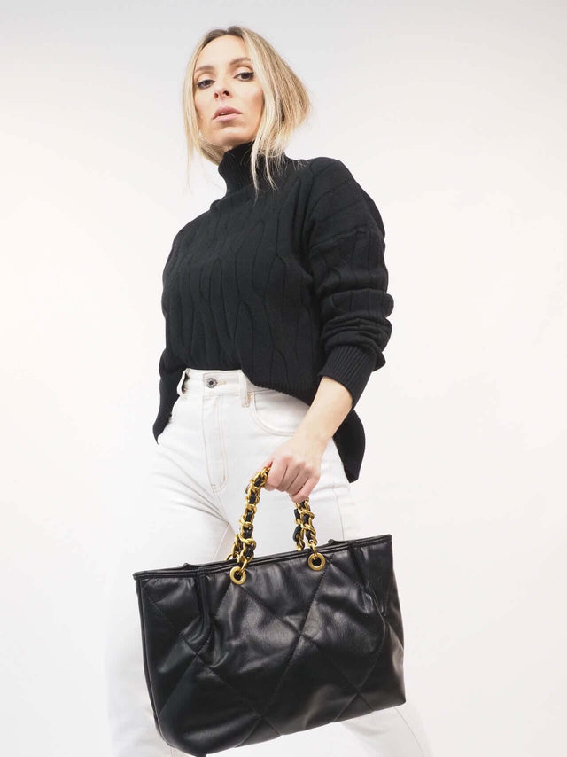 A mala Ecopele tem uma alça para o ombro e uma alça de mão em corrente.