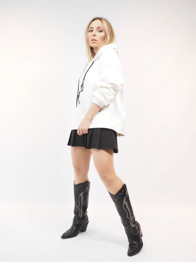 Sweatshirt combinada com mini saia e botas de cano alto.