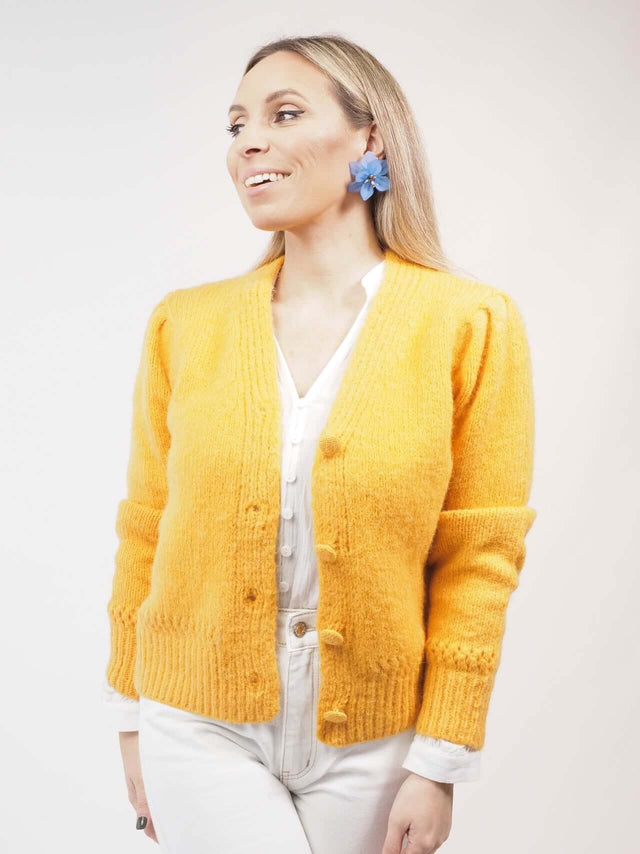 Com decote em bico, um fecho de botões no mesmo tecido e cor é assim o nosso casaco de malha.