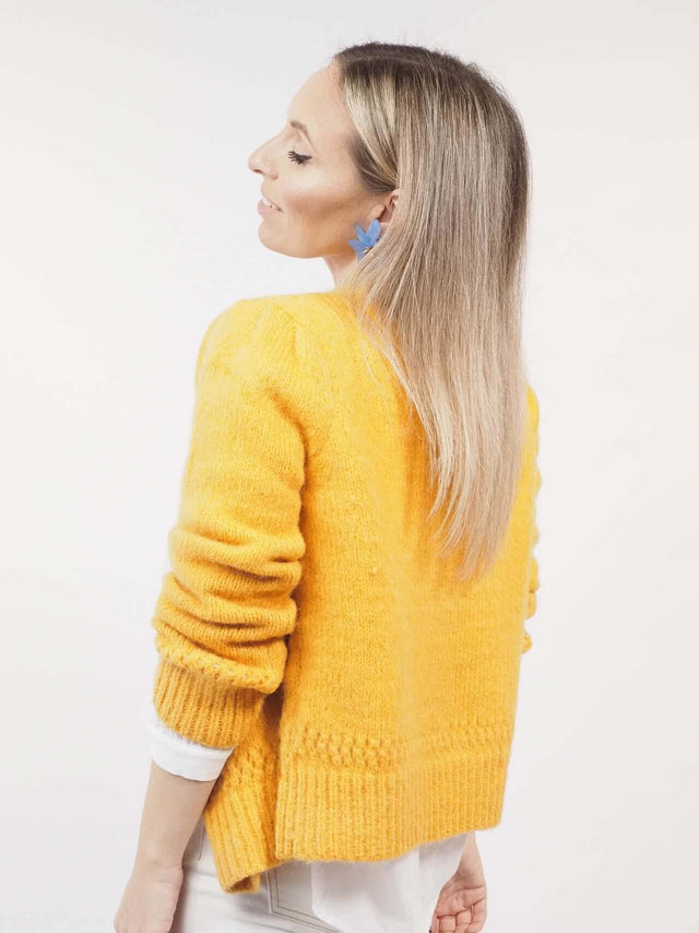 Casaco de malha com pormenor visto de trás.