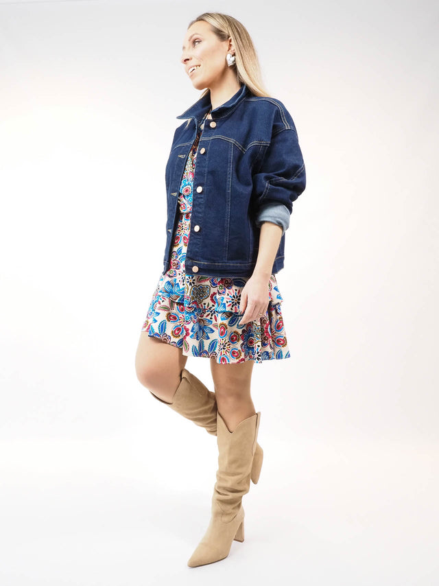 Casaco de ganga combinado com vestido e botas de cano alto.