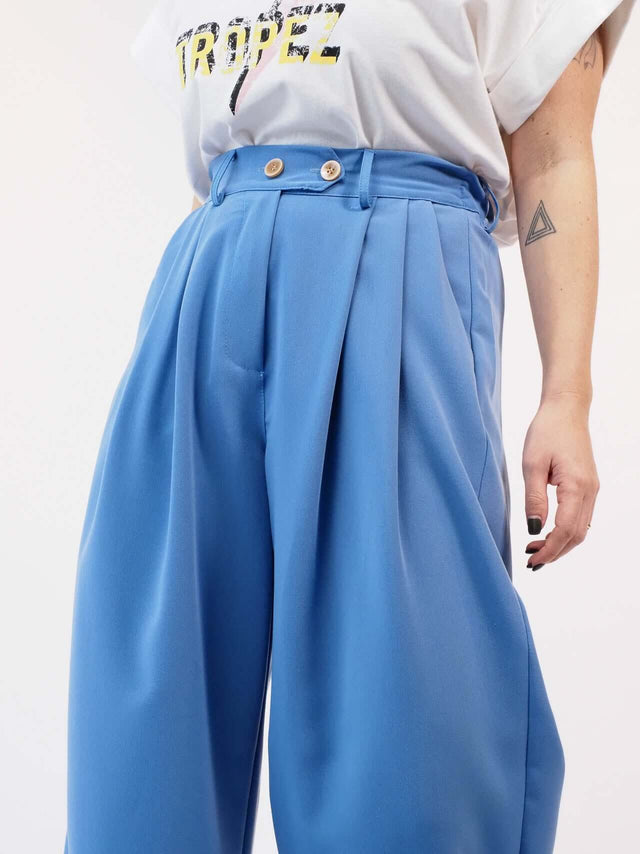 Calças em tecido largas com pregas à frente.