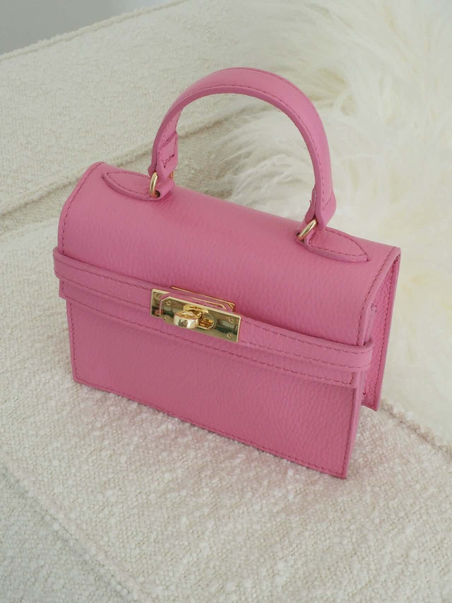 Mala com fecho de metal e pode ser usada com uma alça de mão ou de ombro (tira-colo).