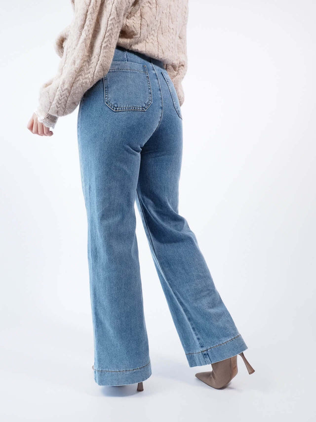 calças de ganga wide leg, com bolsos atrás visíveis.